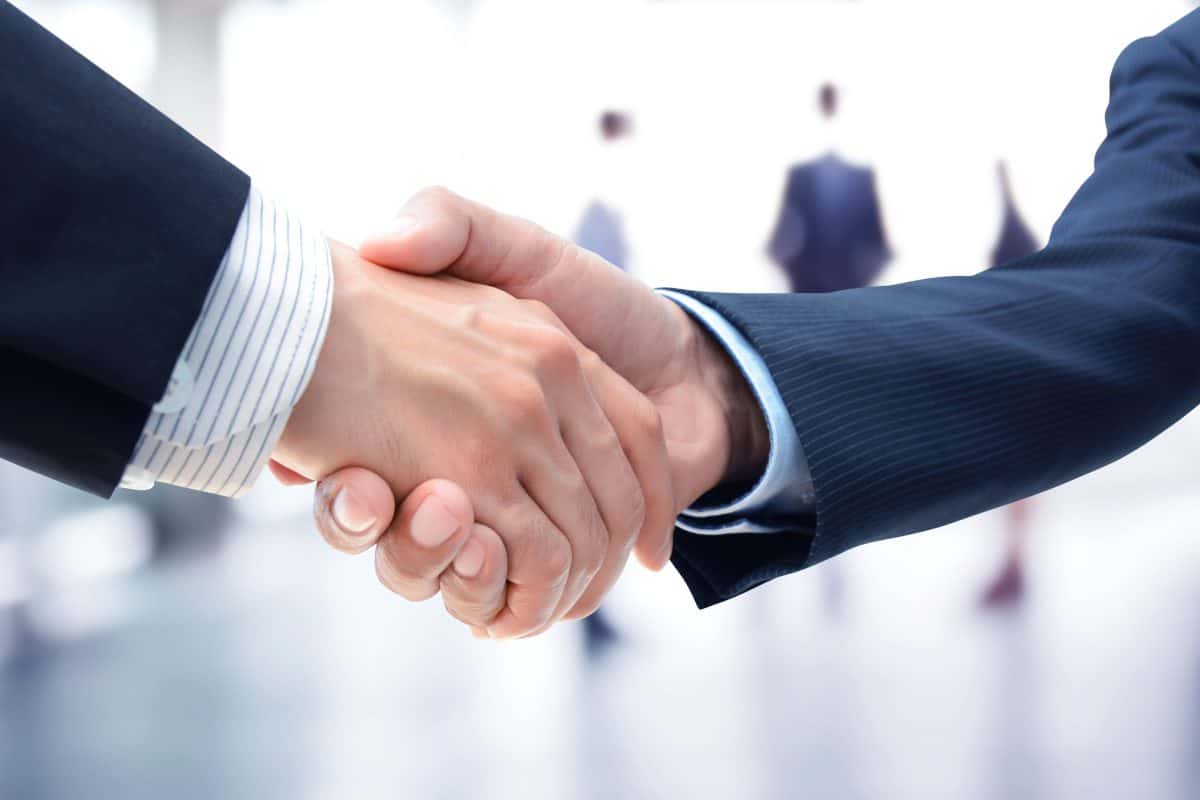 Handshake of businessmen on blur businesspeople background