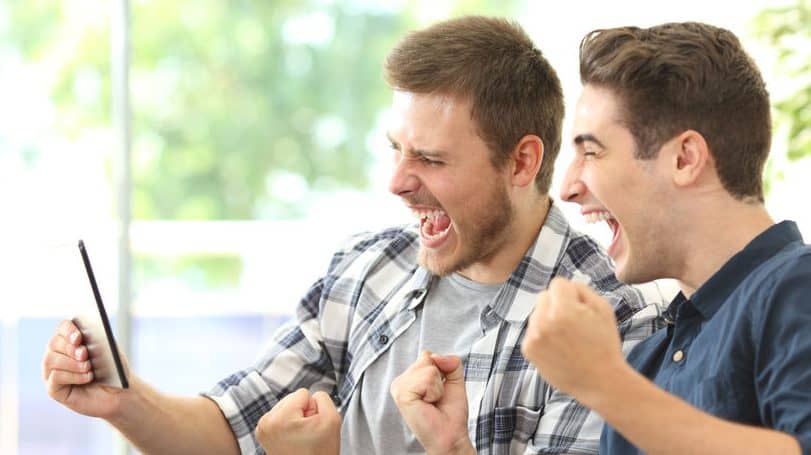 Excited friends watching tv on a tablet