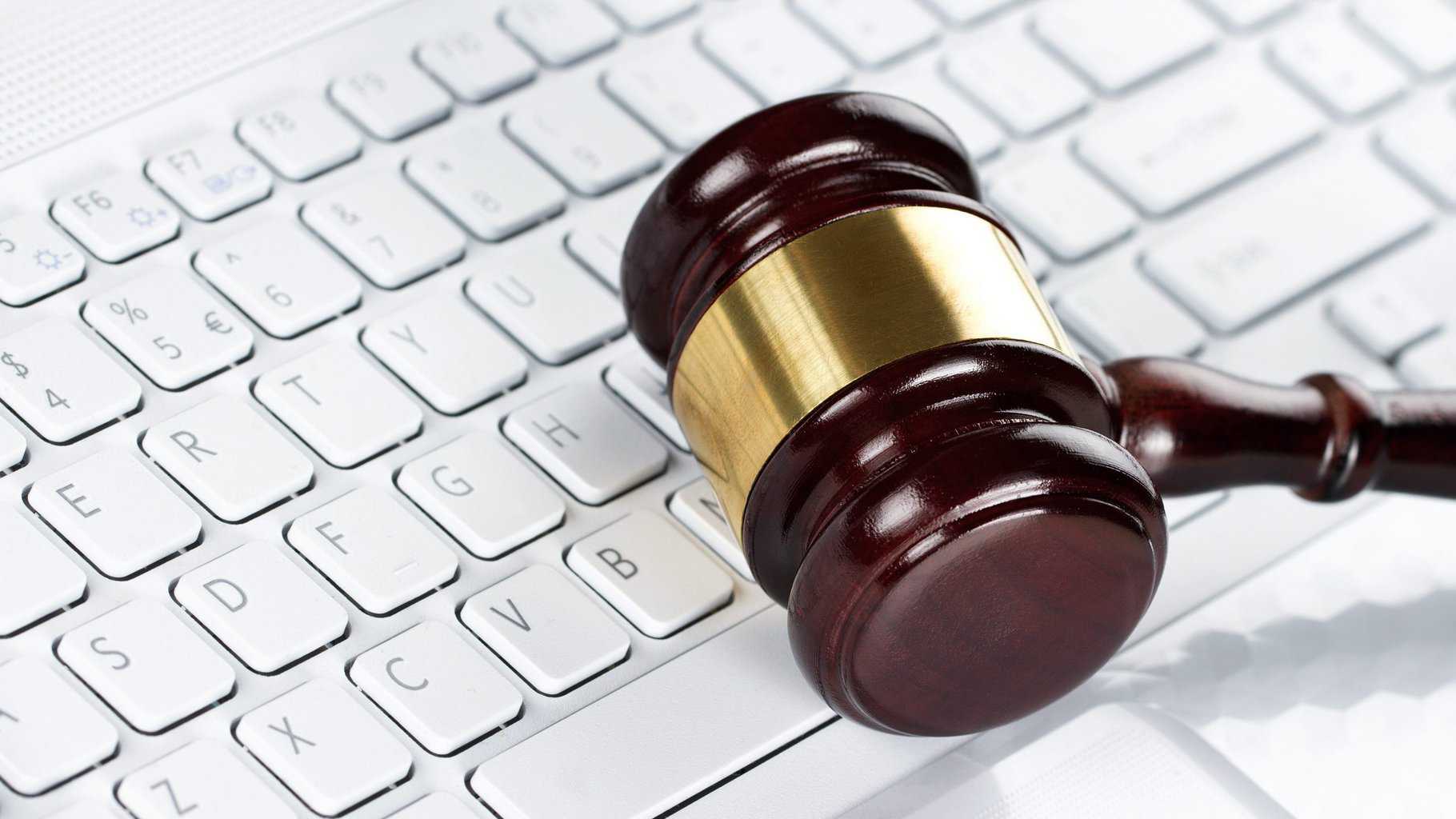 14676860 – close up of wooden gavel at the computer keyboard