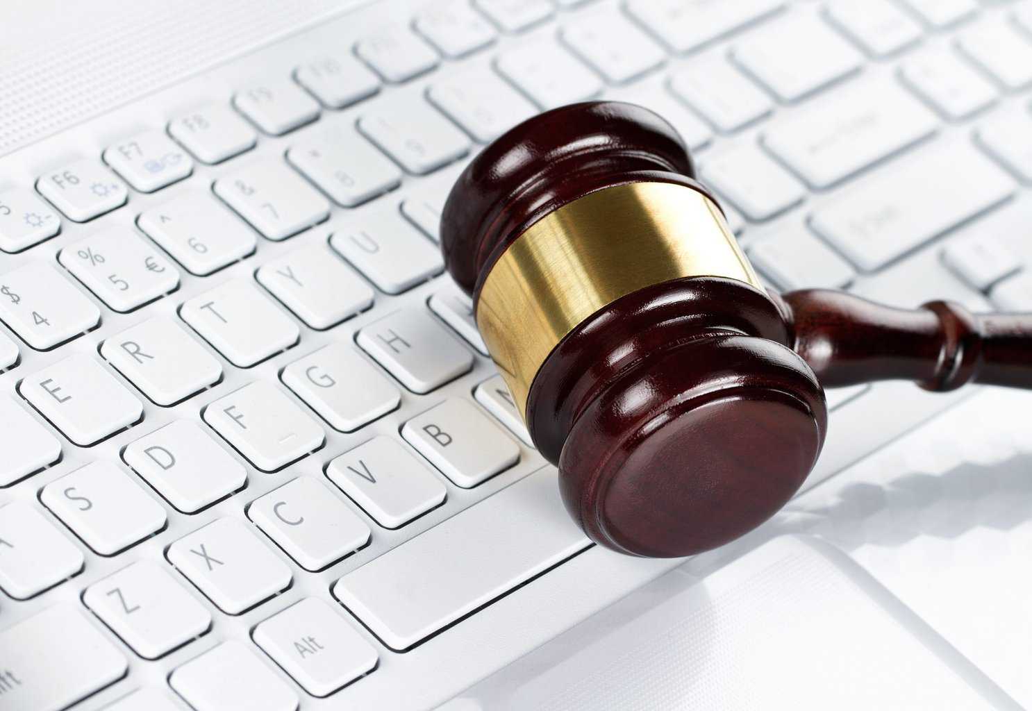 14676860 – close up of wooden gavel at the computer keyboard