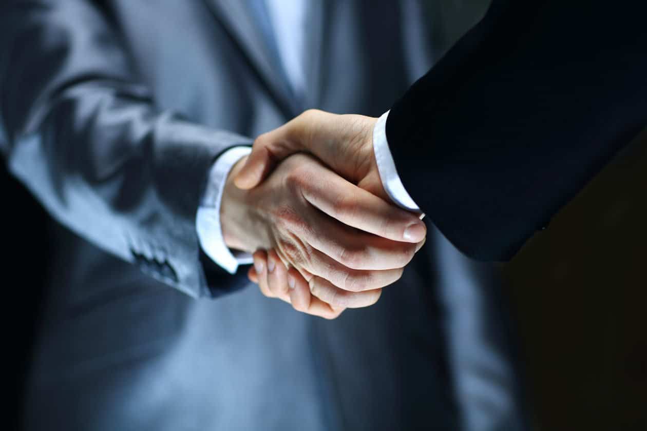 Handshake – Hand holding on black background