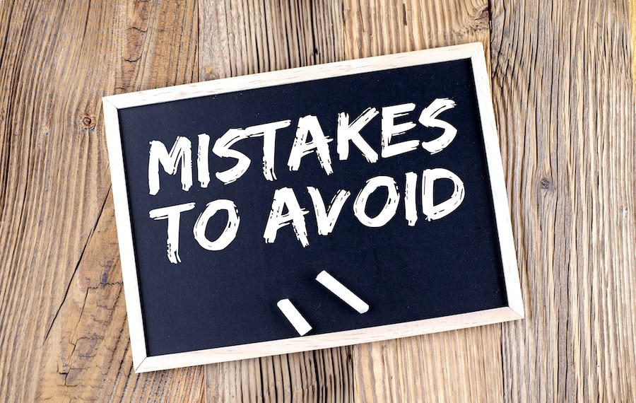 MISTAKES TO AVOID text on a chalkboard on the wooden background