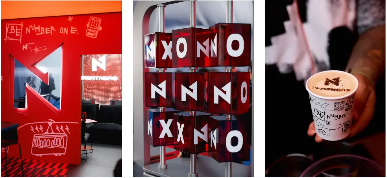 Red branded event display with logo blocks, graphic wall art, and a latte in a custom illustrated cup.